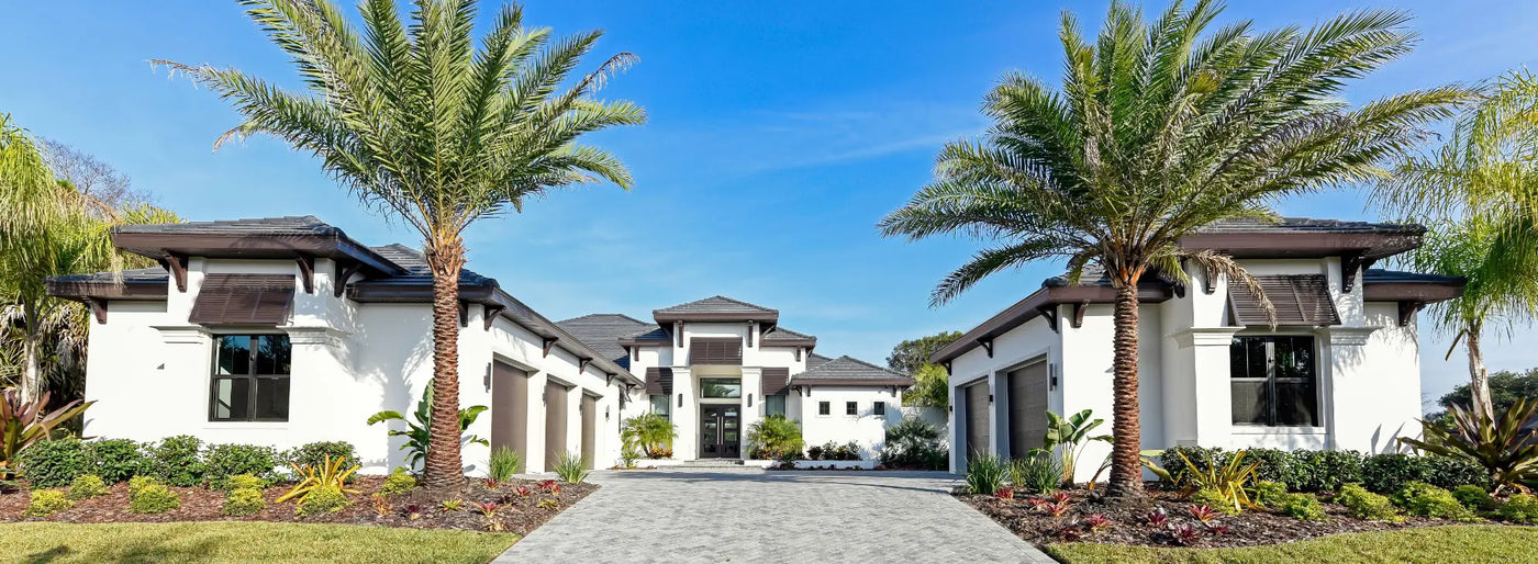 Photograph of custom home with pool house and detached garage